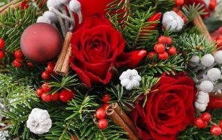 Christmas decoration with red roses, fir, brunia and cinnamon sticks.